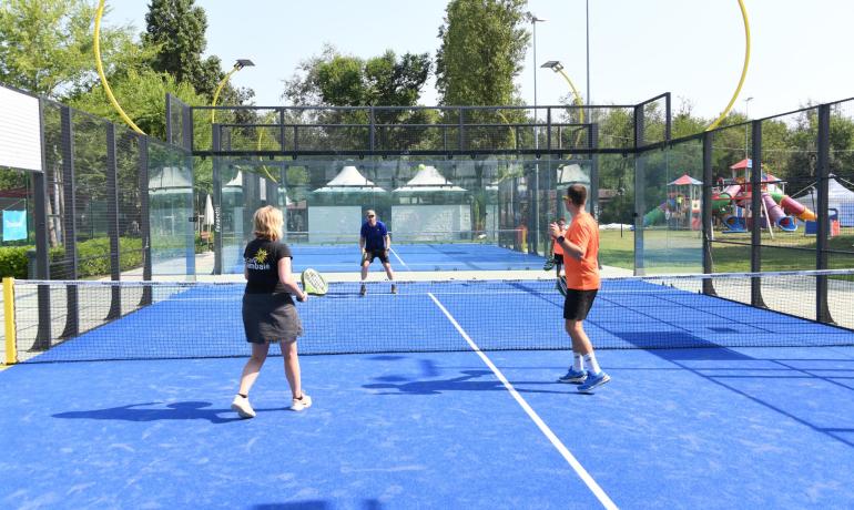 Padelkamp på blå bane, fire spillere i aktion.