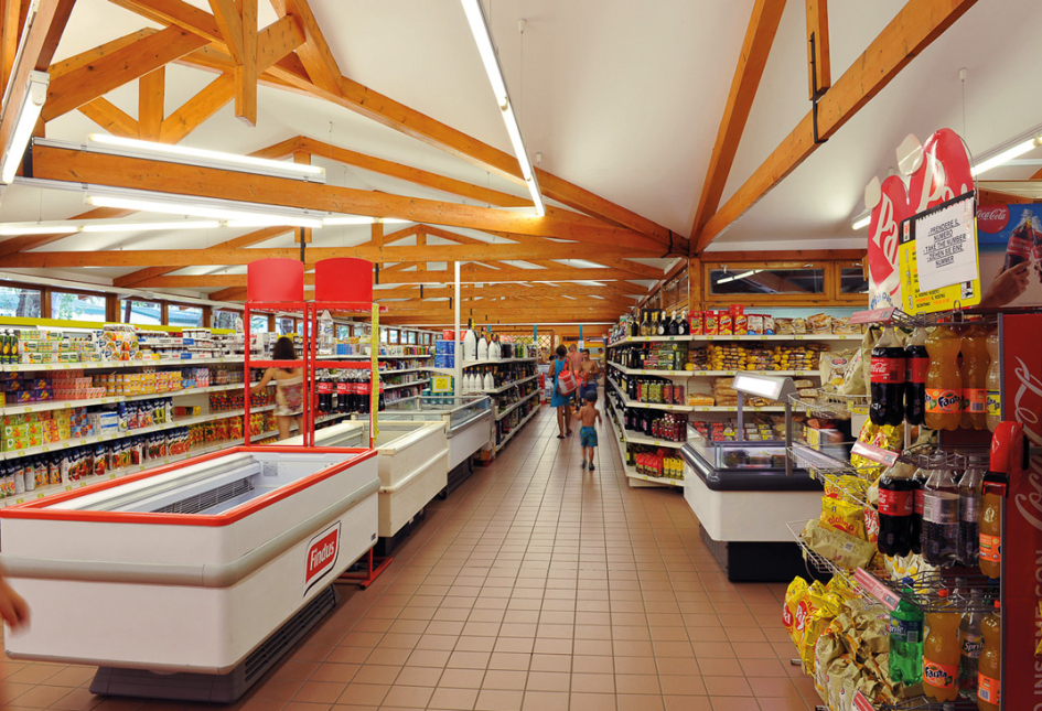 Supermercato con scaffali pieni di prodotti alimentari e bevande, illuminazione moderna.